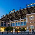 An architecture photograph of the TCU stadium in Fort Worth at night from the ground.